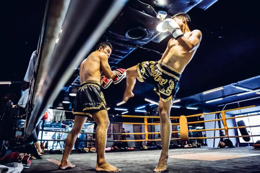 two male Muay Thai fighters fighting in a ring